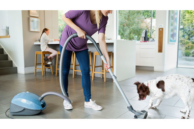 Mother preventing allergies by vacuuming house. Mother preventing allergies by vacuuming house.