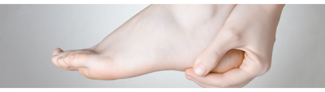 Hand holding foot affected by a heel spur Hand holding foot affected by a heel spur