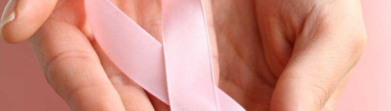 Hand holding a pink ribbon. Hand holding a pink ribbon.