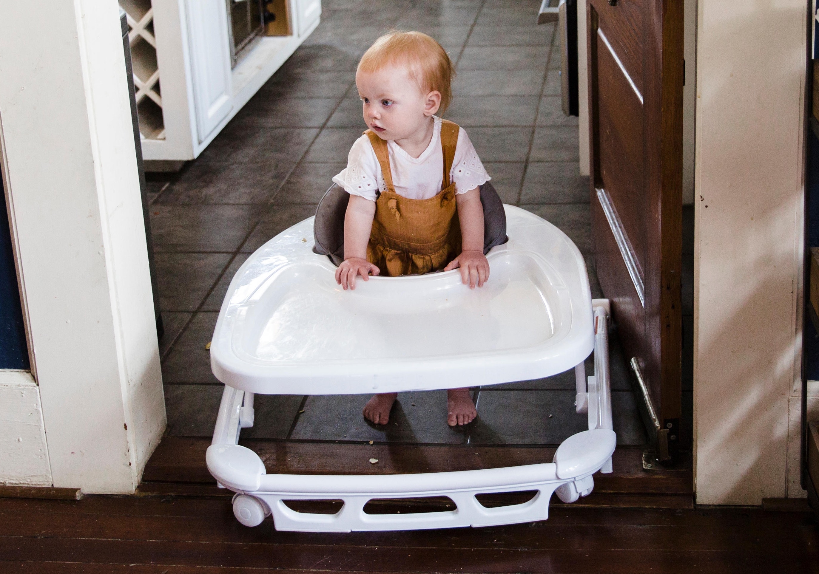 Photo of a baby in a baby walker, that is also an eating surface.