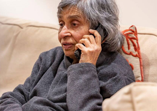 Elderly person with grey hair on phone