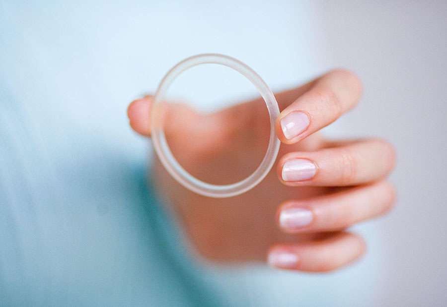 Image of a person holding a vaginal ring in their hand.