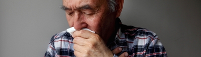 Man coughing into tissue